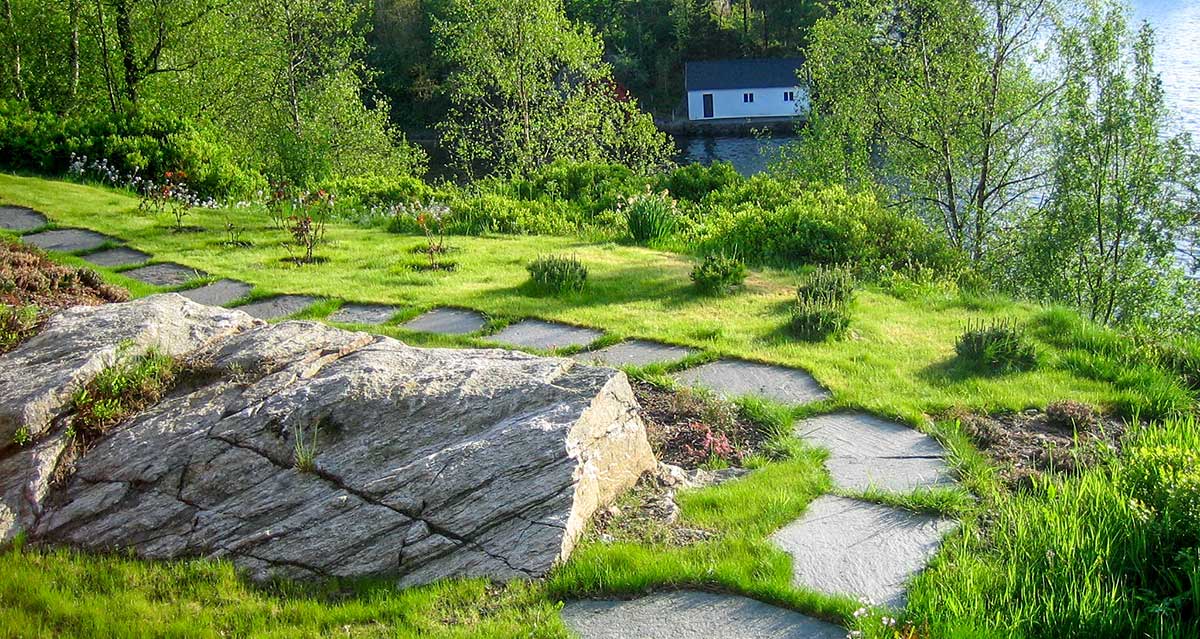 Hage med plen og tråkkheller.
